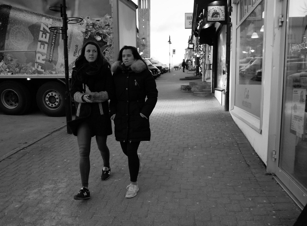 Photo en noir et blanc de deux jeunes femmes passant devant le cabinet du docteur Calvin, sur le trottoir pavé de l'avenue Lexington, début décembre. Elles sont emmitouflées dans des manteaux d'hiver. 